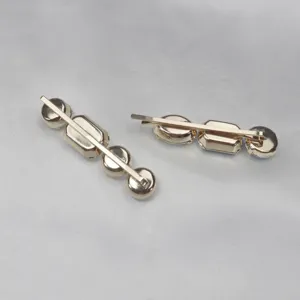 Detailed view of gold-tone metal hair clips adorned with sparkling rhinestones for bridal wear.