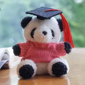 Primo piano dettagliato di un simpatico panda di peluche con cappello di laurea e maglia.