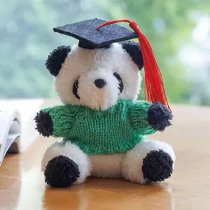 Peluche panda di laurea con maglione verde e berretto, simpatico giocattolo imbottito.