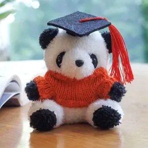 Primo piano dettagliato di un simpatico peluche panda di laurea con berretto e maglione.