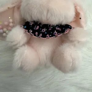 Cute plush long-eared rabbit plush toy pendant detail shot, showing soft texture and floral collar.