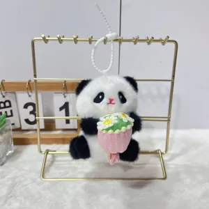 Cute plush panda doll pendant detail showing fluffy texture and small flower bouquet design.