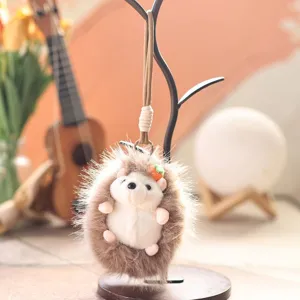 Plush hedgehog keychain detail, cute fluffy animal pendant with mini carrot charm for bag.
