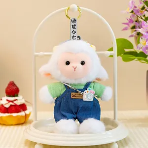 Cute little sheep plush toy pendant wearing green sweater and blue denim overalls with camera.
