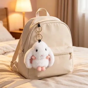 Stylish beige backpack paired with a soft white lop-eared rabbit plush keychain accessory.