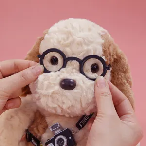 Cute plush puppy toy detail view featuring round black glasses and mini camera accessory.