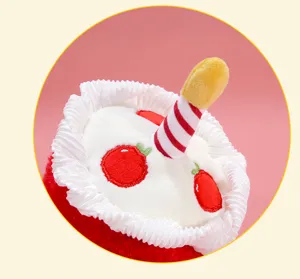 Close-up detail of cute birthday cake plush toy pendant with candle and embroidered fruit.