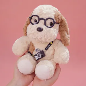 Cute puppy plush toy with round glasses and mini camera, soft stuffed animal doll for gift.