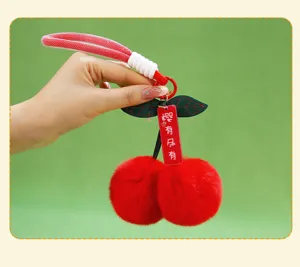 Detailed view of the red plush cherry keychain, showing soft fluffy texture and cute design.