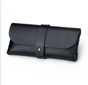 Nahaufnahme eines eleganten schwarzen Leder-Brillenetuis mit sicherem goldenen Druckknopf.
