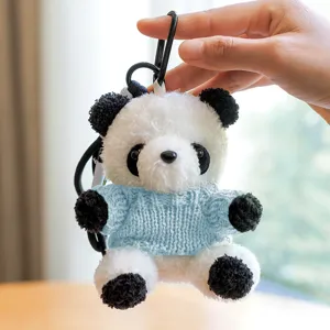 Dettaglio panda di peluche carino, morbido maglione lavorato, ciondolo per borsa.