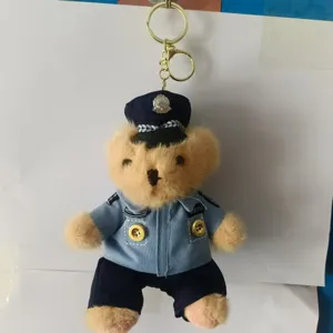 Detail shot of cute plush bear keychain wearing a police uniform and metal ring.