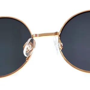 Close-up detail view of gold-rimmed round metal children sunglasses nose bridge and pads.