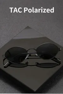 Detail view of black oval polarized sunglasses with metal frame, retro style UV protection.