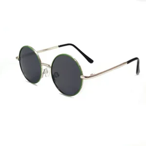 Closeup of round metal kids sunglasses detail showing green frame rim and black temple tip.