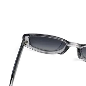 Detailed view of women polarized sunglasses, transparent gray frame, gradient lenses.