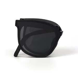 Gros plan de lunettes de soleil pliables noires, design compact, lunettes d'été portables.
