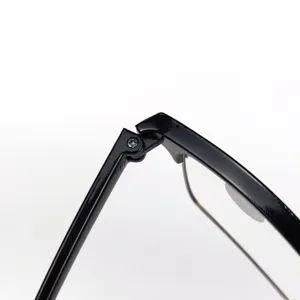 Nahaufnahme des Scharniers und Bügels einer schwarzen Brille mit Metallschraube.