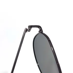 Close-up detail of metal pilot sunglasses hinge, durable frame construction, premium design.