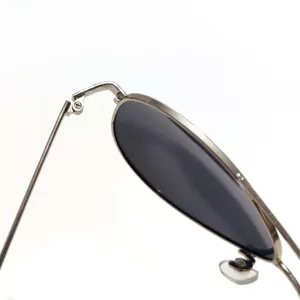 Metal sunglasses detail shot showing precise hinge and dark polarized lens for men.