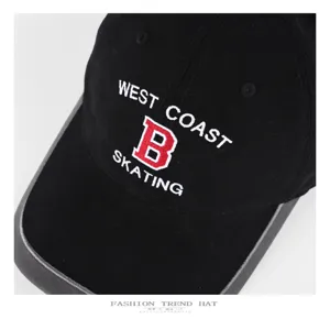 Close-up detail of the black baseball cap showing embroidered letter B and West Coast text.