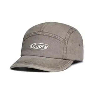 Close-up detail of grey washed denim 5-panel baseball cap with front embroidery.