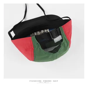 Detalle de gorra impermeable color-block, que muestra claramente la correa y hebilla ajustables.