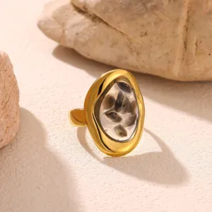 Vue detaillee de la bague en acier inoxydable dore avec pierres irregulieres et style geometrique.