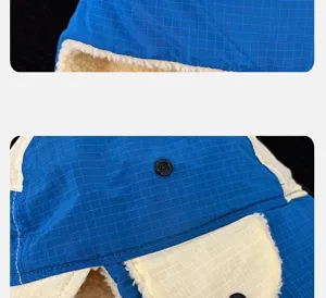 Détail de bonnet d'hiver chaud, tissu à carreaux bleus, doublure en polaire, boutons.