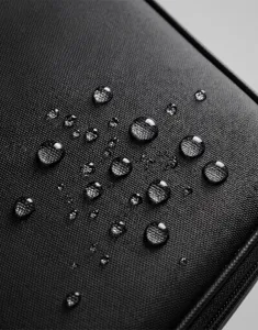Waterproof black travel toiletry bag fabric detail, durable water-resistant storage pouch.