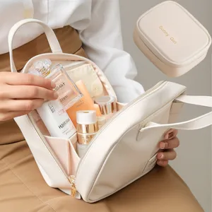 Vista dettagliata dell'elegante borsa cosmetica bianca con scomparti multipli e cerniera dorata.