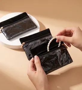 Clear detail shot showing black transparent cosmetic storage pouch holding pearl bracelet.