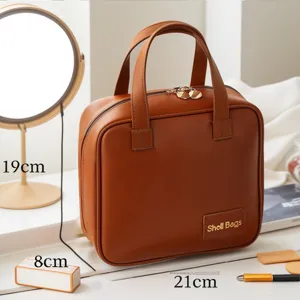 Borsa cosmetica marrone in pelle con manico, grande custodia impermeabile per trucco da viaggio.