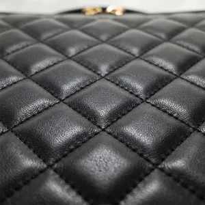 Close up of black quilted leather texture cosmetic bag with fine stitching detail.