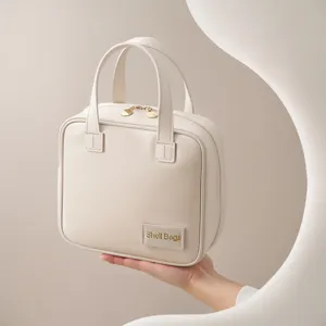 Elegante borsa cosmetica beige con manico e cerniera, perfetta per viaggi e conservazione.