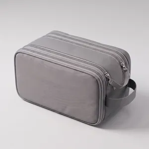 Grey multi-compartment travel toiletry bag and cosmetic organizer with durable zipper design.