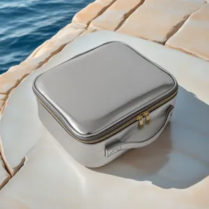 Portable travel cosmetic bag with handle and mirror for women, stylish silver makeup organizer.