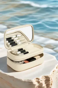 Vue détaillée de l'organisateur de maquillage beige à plusieurs couches avec des pinceaux.
