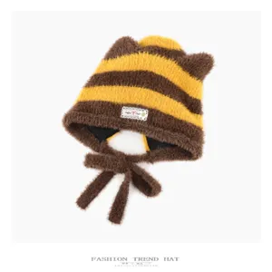 Cute brown and yellow striped bear ear knitted hat detail, warm plush winter beanie design.