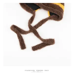 Detail view of the cute brown and yellow striped plush bear ear knit hat with long straps.