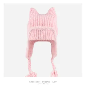 Pink knit cat ear hat detail, thick warm earflap winter beanie with braided tassel strings.