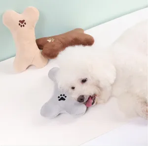 Cute pet plush bone toy detail shot featuring soft fabric and adorable paw print embroidery for dogs.
