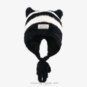 Black and white striped plush winter hat with cute bear ears and tassel earflaps, warm knit cap.