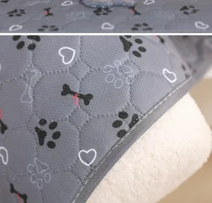 Detailed view of the thick washable dog pee pad featuring cute paw and bone prints.