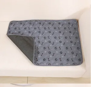 Detail view of washable grey pet pee pad with anti-slip backing, paw and bone pattern.