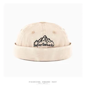 Close-up detail of the washed denim docker cap featuring mountain embroidery and streetwear style.