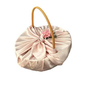 Französischer Brautjungfern Geschenkkorb mit rosa Satinstoff Umwicklung und geflochtenem Henkel.