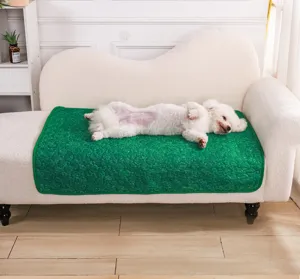 Vista dettagliata di un tappetino igienico verde per animali su un divano bianco con un cane.