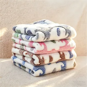 Soft plush pet blanket detail shot, flannel material with cute pattern design, cozy pet mat.