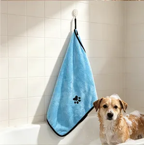 Vista dettagliata dell'asciugamano in pile corallo blu per animali con zampa nera nel bagno.
